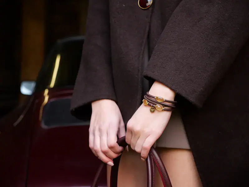 Lebensfreude im Herzen, symbolisiert durch eine Person mit stilvollen Armbändern und eleganter Kleid.